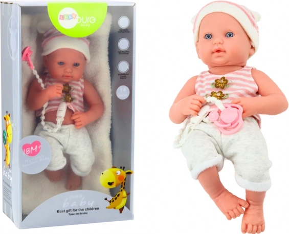 Baby doll in a white‑pink outfit with pacifier and cap